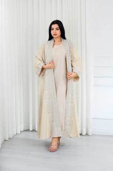 جلابية قماش بطول يصل للكاحل مكونة من قطعة سادة وقطعة مزينة بالترتر اللامع على أطراف الأكمام وعلى طول الجلابية الخارجي ومنتصف الظهر