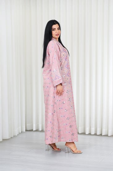 جلابية قماش بطول يصل للكاحل بأكمام بنهايات واسعة وياقة مزينة بالترتر وبالتطريزات البارزة على كامل القماش