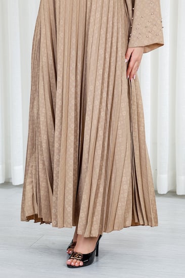 جلابية قماش بطول يصل للكاحل بياقة قصيرة بنهايات أكمام واسعة مزينة باللؤلؤ البراق