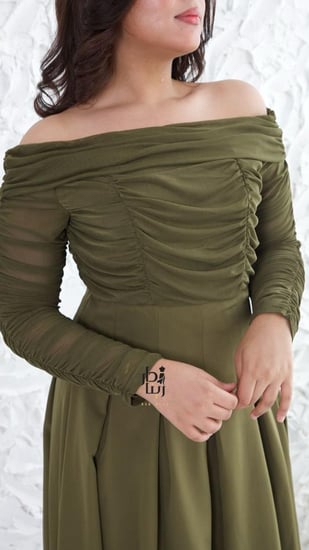 تفاصيل تنورة الفستان الواسعة بكسرات أمامية في فستان تب زيتي