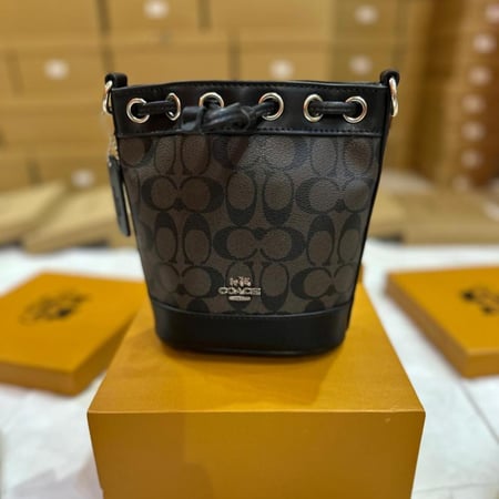 حقيبة باكيت نسائية أنيقة من Coach بنقشة Signature الكلاسيكية ماستر كوالتي
