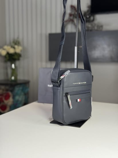 شنطة تومي هيلفيقر رجاليه بجلد ازرق قوي مزين بالشعار  ESSENTUAL pq mini Reporter bag limited