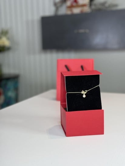 اسوار كارولينا مزين على شكل باو ذهبي مع لولو متدلي carolina Herrera gold bow pearl bracelet