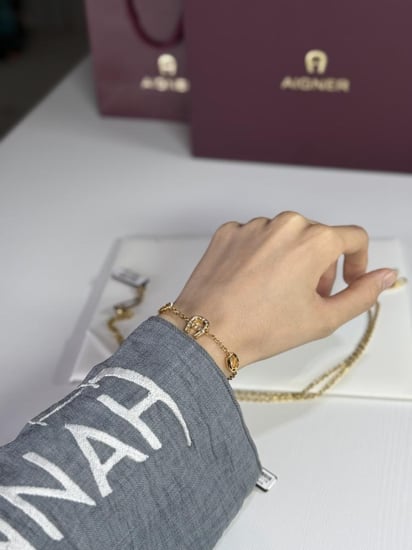 طقم اجنر سلسلة و اسوار ذهبي بالعلامه المرصع بالكريستال A670128. B20 Aigner gold necklace and bracelet set women