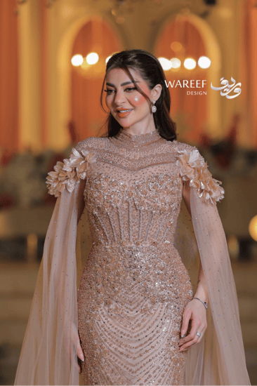 فستان سهرة فاخر بترتر ذهبي وأكمام شفافة مزينة بالورود