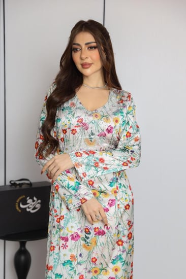 جلابية طويلة باللون السكري بنقشة زهور ملونة وقصة انسيابية