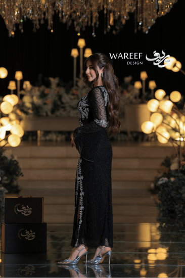 فستان سهرة أسود فاخر مطرّز بالفضي وأكمام دانتيل منسدلة لإطلالة ملكية راقية