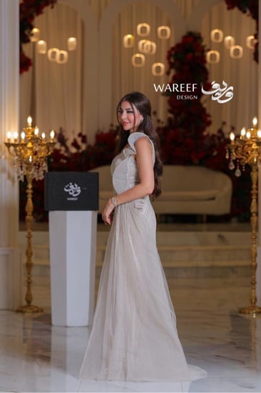 فستان ملكي فضي بتطريز لامع وقصّة درابيه أنيقة