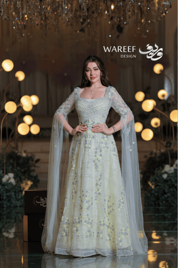 فستان سهرة ليموني مطرّز بلمسات فضية ساحرة وأكتاف شفافة لإطلالة ملكية راقية