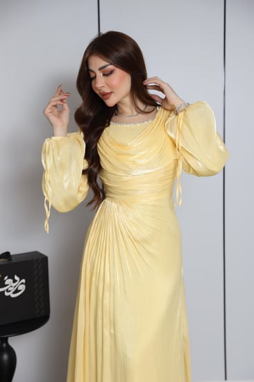 فستان سهرة أصفر ليموني بتصميم انسيابي وتفاصيل أنثوية ناعمة