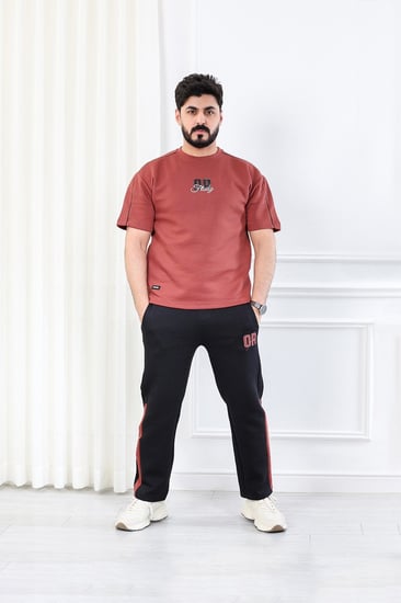 طقم رجالي اوفر سايز نص كم بنطال طويل مزين بطبعة بأحرف صغيرة على الجهة الأمامية من الطقم وكبيرة على ظهر التيشرت