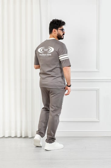 طقم رجالي أوفر سايز نص كم بنطال طويل مزين بخطوط أفقية على الكم والبنطال مع طباعة على صدر التيشرت وظهره