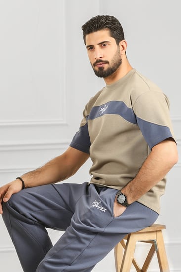 طقم رجالي أوفر سايز نص كم بنطال طويل مزين بخط أفقي مطابق ل لون البنطال وكتابة بحجم صغير