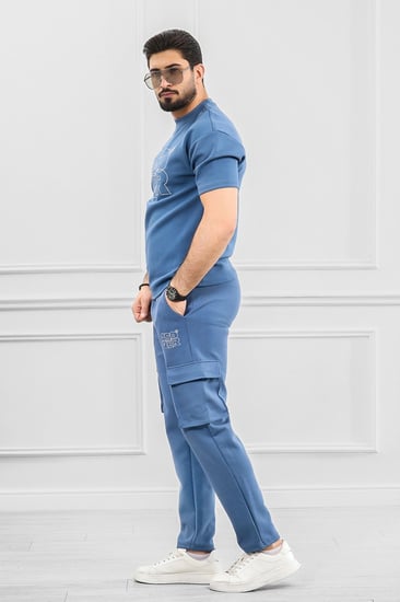 طقم رجالي أوفر سايز نص كم بنطال طويل بجيب جانبية بلون موحة وطبعة كتابية محددة الأطراف