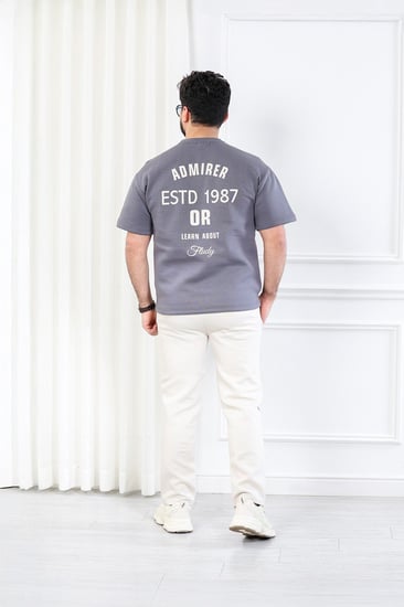 طقم رجالي اوفر سايز نص كم بنطال طويل مزين بطبعة بأحرف صغيرة على الجهة الأمامية من الطقم وكبيرة على ظهر التيشرت