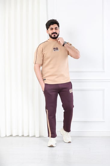 طقم رجالي اوفر سايز نص كم بنطال طويل مزين بطبعة بأحرف صغيرة على الجهة الأمامية من الطقم وكبيرة على ظهر التيشرت