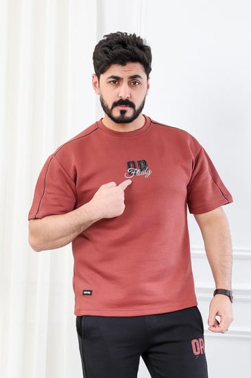 طقم رجالي اوفر سايز نص كم بنطال طويل مزين بطبعة بأحرف صغيرة على الجهة الأمامية من الطقم وكبيرة على ظهر التيشرت