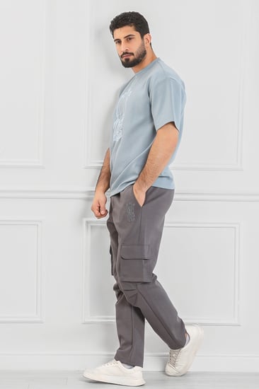 طقم رجالي أوفر سايز نص كم بنطال طويل بجيب جانبية وتيشرت بلون مختلف مزين بطبعة رسومية