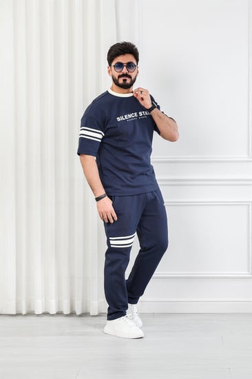 طقم رجالي أوفر سايز نص كم بنطال طويل مزين بخطوط أفقية على الكم والبنطال مع طباعة على صدر التيشرت وظهره