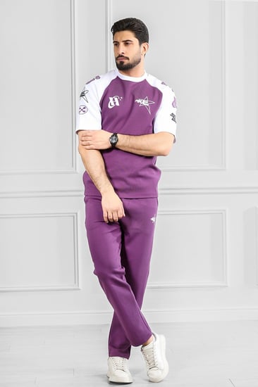 طقم رجالي أوفر سايز نص كم بنطال طويل تيشرت مزين بطبعات رسومية بلون مختلف
