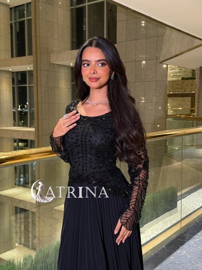 فستان سهرة أسود بتطريز فاخر وأكمام شفافة وتنورة بليسيه