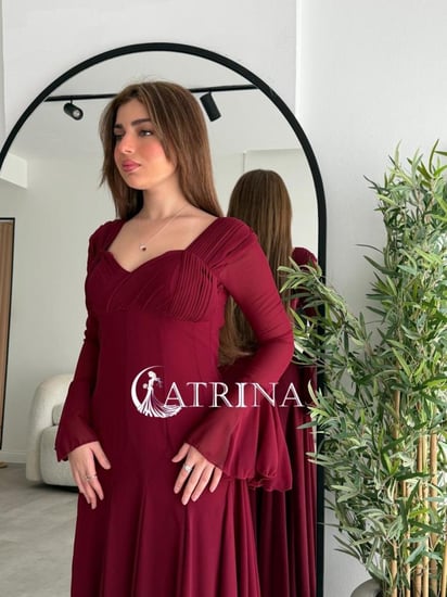 فستان خمري بانسياب ناعم وأكمام واسعة أنثوية