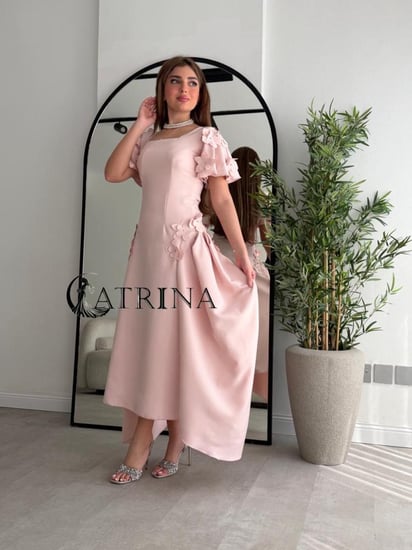 فستان وردي ناعم بقصة أنثوية وتفاصيل زهرية ثلاثية الأبعاد