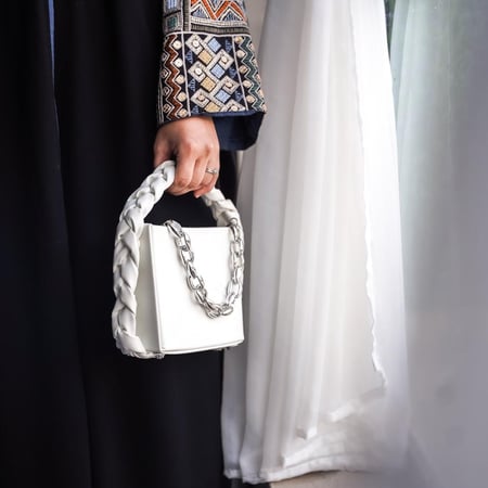 حقيبة بيضاء أنيقة بمقبض مجدول وسلسلة فضي لأسلوب عصري ومميز