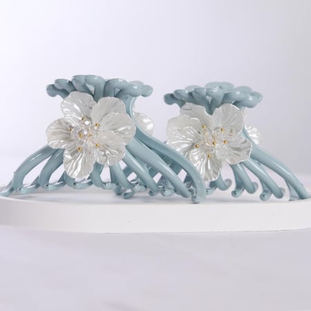 2 قطع شباصات شعر بلون أزرق فاتح بزهرة بيضاء بتفاصيل ذهبي أنيقة