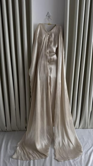 فستان سهرة بيج طويل بكتف واحد بطيات انسيابية مع كاب فخم للسهرات الراقي