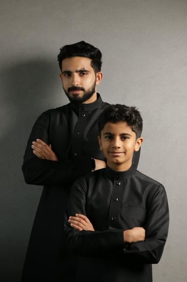 تصميم ثوب أولاد أسود أنيق مع أزرار فاخرة وعصرية.