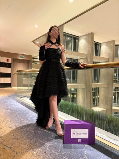 فستان أسود بتنورة قصيرة مزركشة وفتحة صدر مطرزة مع تفاصيل لؤلؤ