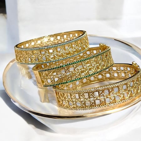 سوار عريض بتصاميم  مزخرفة ومميزة مستوحاة من كارتير مع صفين من الزركون الملون على الحواف مطلي ذهب عيار ١٨.                         MB-285