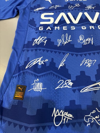 تيشيرت الهلال الأساسي 2025/26 مُوقع من نجوم الفريق