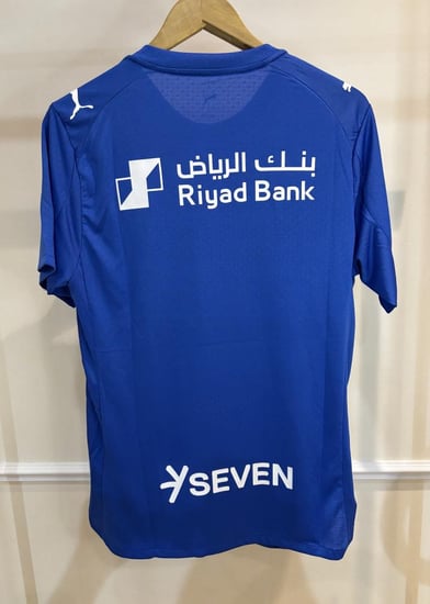 تيشيرت الهلال الأساسي 2025/26 مُوقع من نجوم الفريق