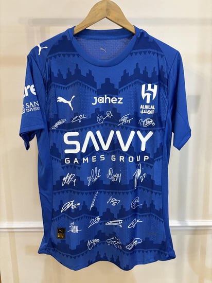 تيشيرت الهلال الأساسي 2025/26 مُوقع من نجوم الفريق