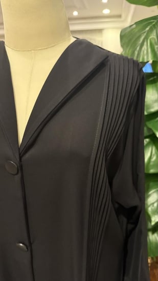 عباية سوداء ساده مزينه بالكسرات من الجنبين ومن الاكمام