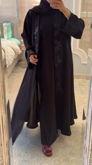 عباية سوداء مزينه بالورود وفيها قطعه داخليه مثل الفستان