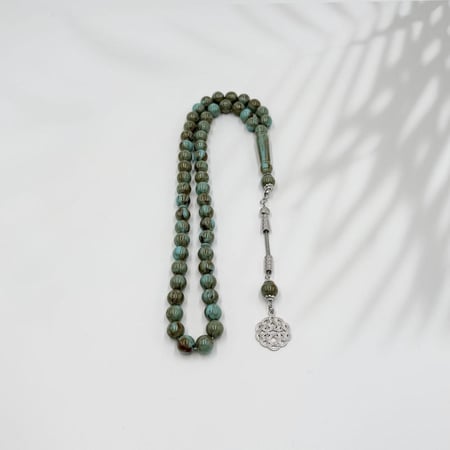 سبحة بخيط أسود وكور بلون رخامي وحلقة دائرية رصاصية مزخرفة نهاية السبحة