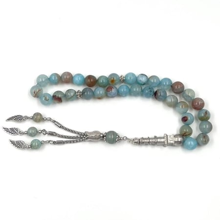 سبحة من العقيق براج بلون أزرق فاتح مع شرابة فضية في يد رجل