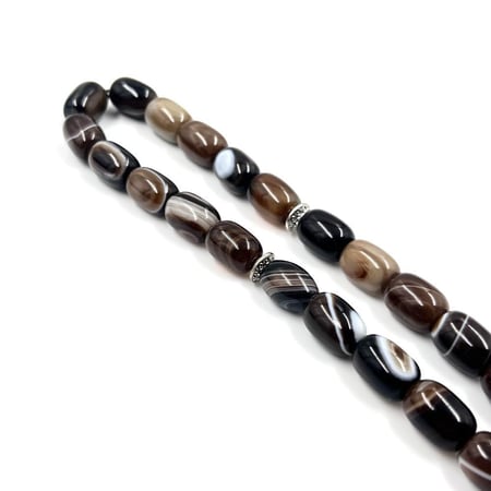 لقطة مقربة لخرز عقيق كبدي بيضاوي 10 مم بتدرجات بنية وسوداء