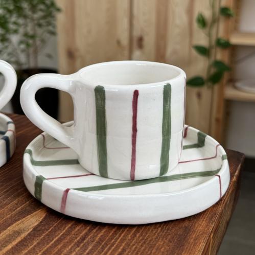 كوب مع طبق مخطط اخضر