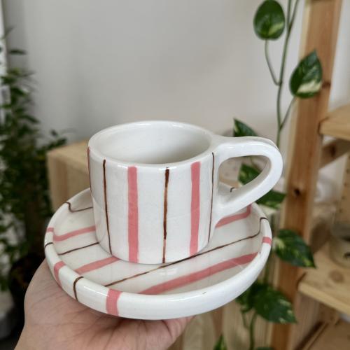 كوب مع طبق مخطط وردي