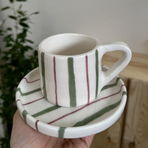 كوب مع طبق مخطط اخضر