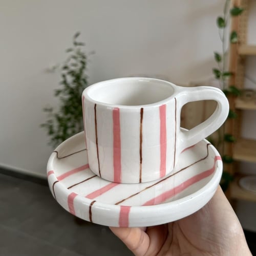 كوب مع طبق مخطط وردي