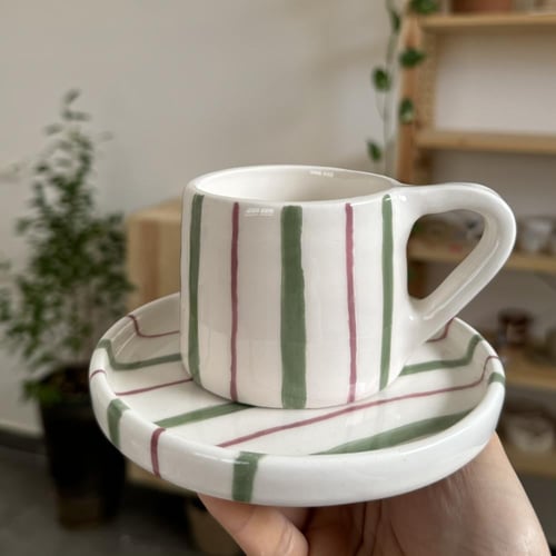 كوب مع طبق مخطط اخضر