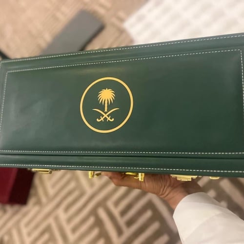 شنطة جلد زيتي بقفل أرقام +شعار سيفين ونخلة حجم كيل...