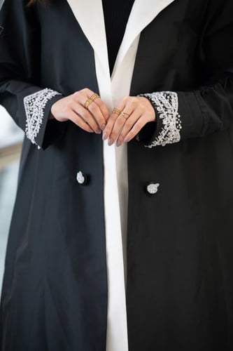 عباية تفتة أسود بتدخيلات ياقة ابيض وشك في الأكمام...