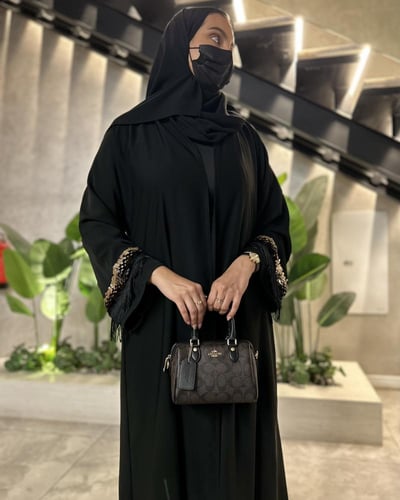 عباية سوداء بتفاصيل ذهبية فاخرة بتصميم أنيق وعصري