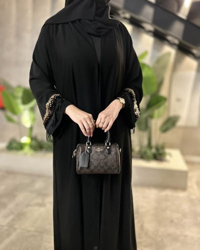 عباية سوداء بتفاصيل ذهبية فاخرة بتصميم أنيق وعصري